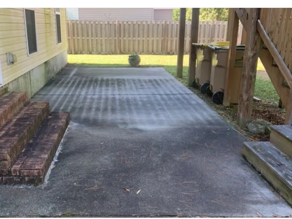 Grimy, algae-stained concrete driveway before pressure washing